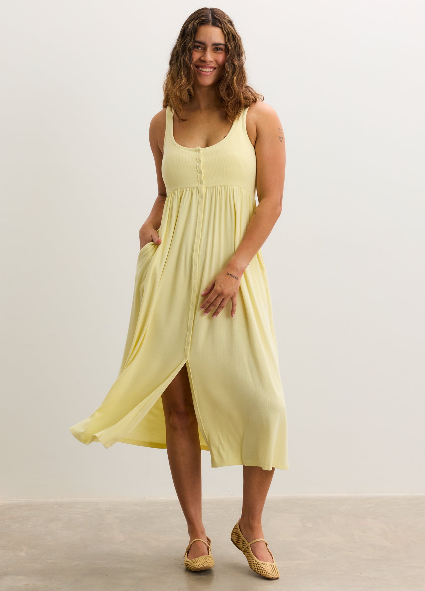 Light yellow ribbed nursing tank dress with buttons and a flowy skirt, designed for maternity use.