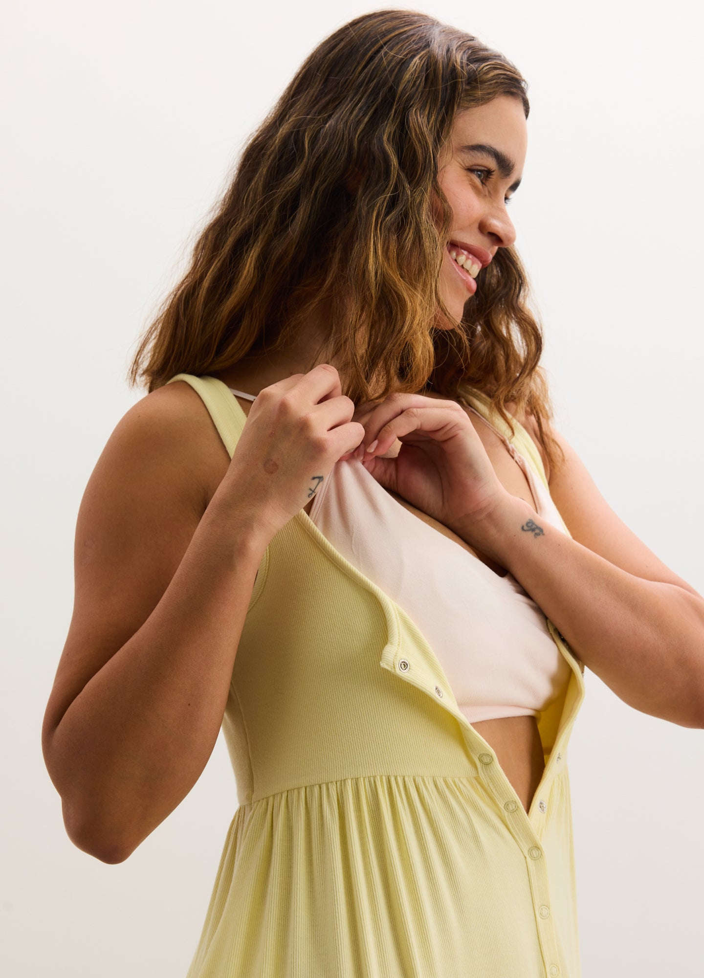 Pale yellow ribbed maternity nursing tank dress with sleeveless design and front button detail.