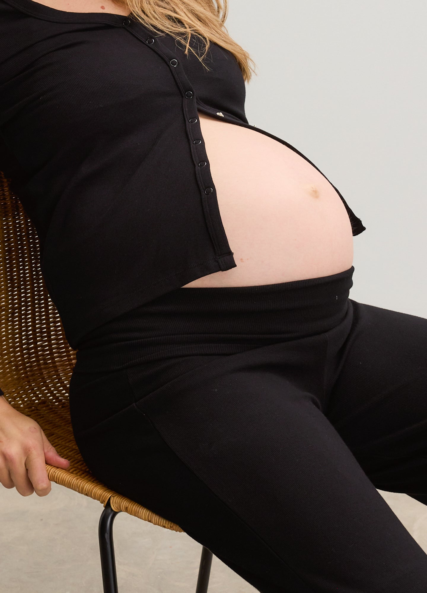 Black ribbed maternity pants with a relaxed fit, designed to sit comfortably under the belly.