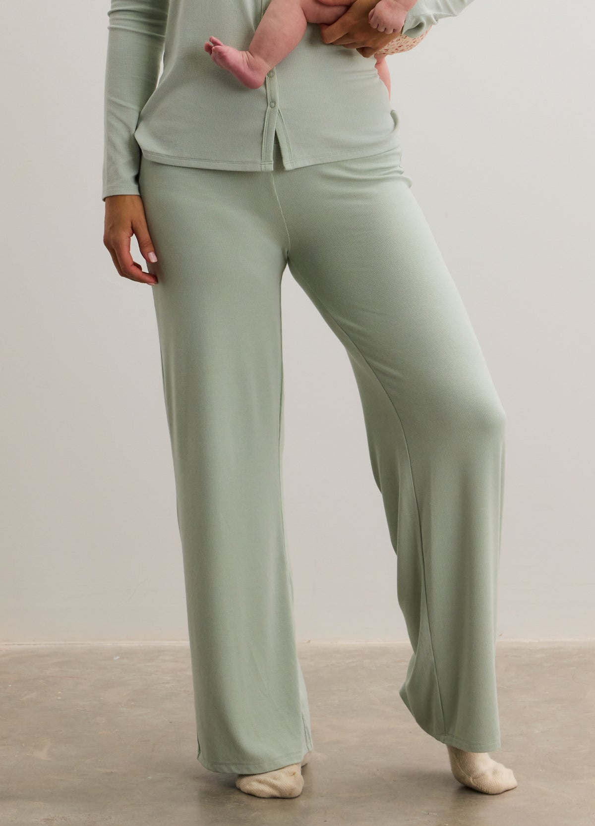 Light sage green ribbed maternity pants with relaxed wide-leg fit and soft fabric.