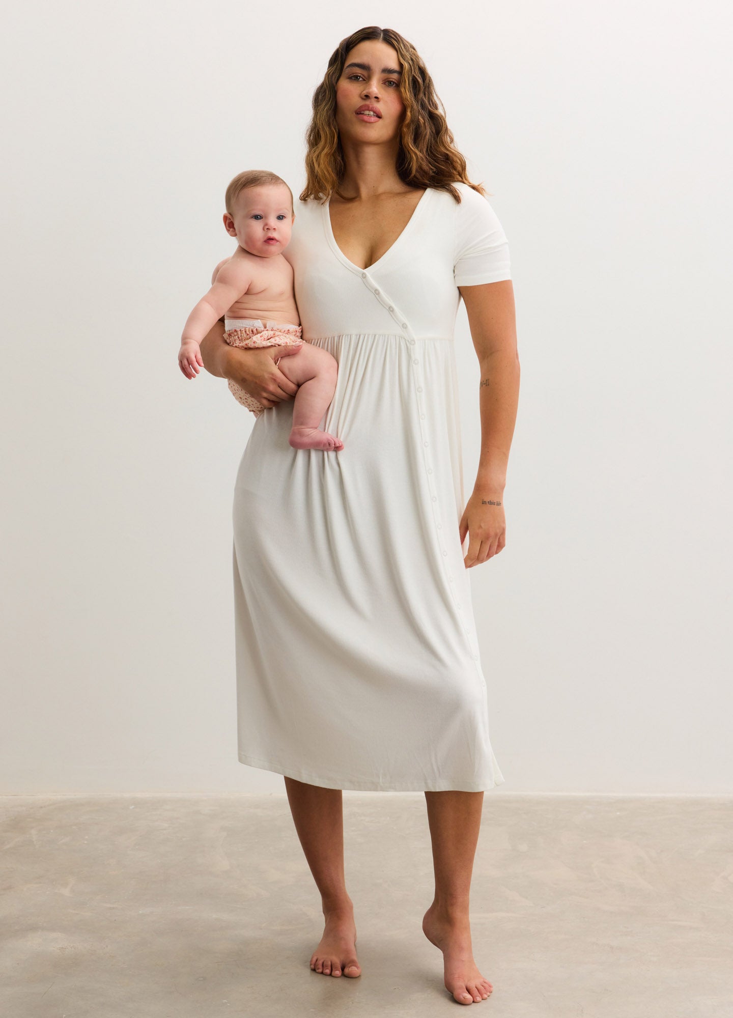 Soft white ribbed maternity maxi dress with short sleeves and V-neck, side seam detail.