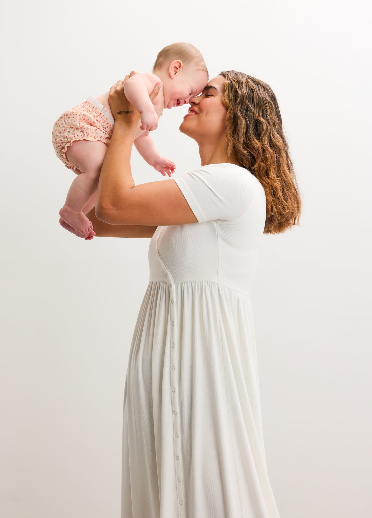 White ribbed nursing maxi dress with short sleeves and side seams, worn by a pregnant woman.