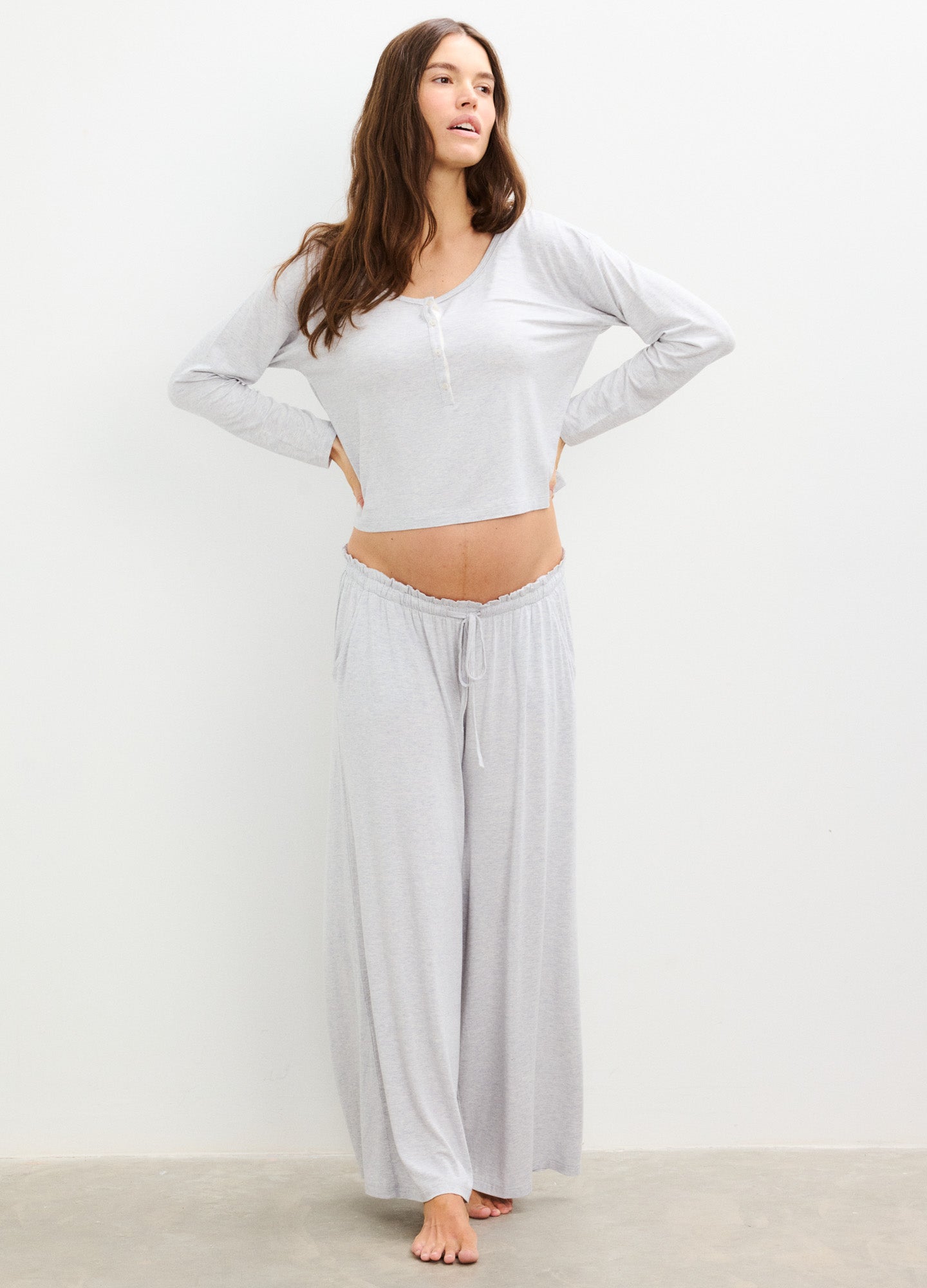 Light gray soft-knit maternity long sleeve tee with wide scoop neck and loose fit, paired with matching wide-leg pants.