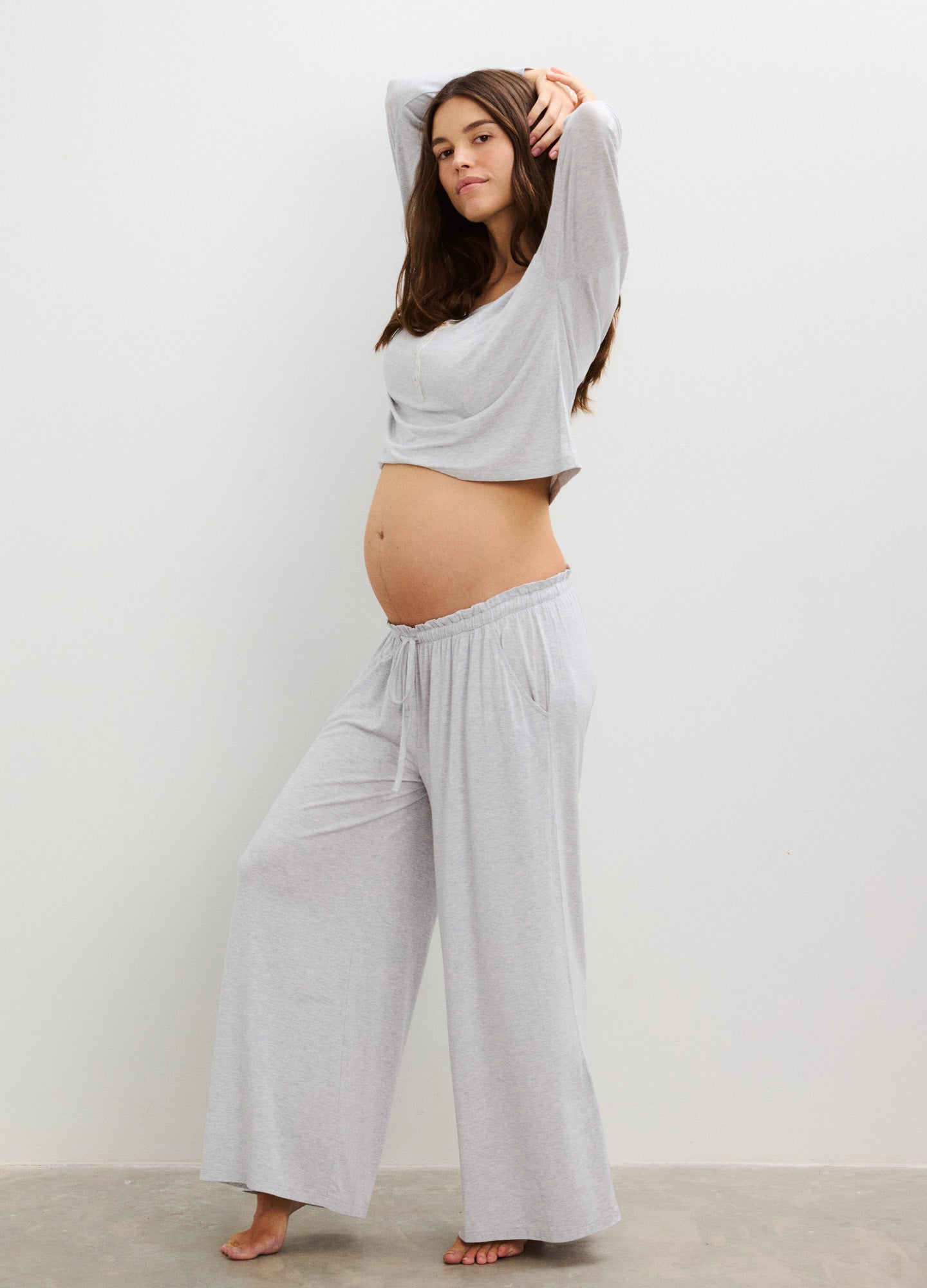 Light gray wide-leg maternity pants with stretchy waistband, worn by pregnant woman, soft fabric.