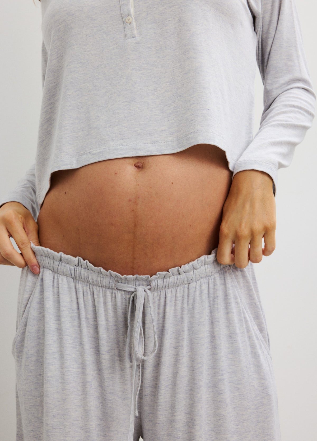 Light gray soft knit maternity pants with elastic waistband and drawstring, designed for comfort during pregnancy.