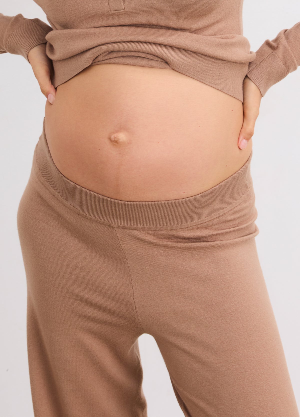 Light brown knit crop pants with a soft, stretchy waistband designed for maternity comfort.