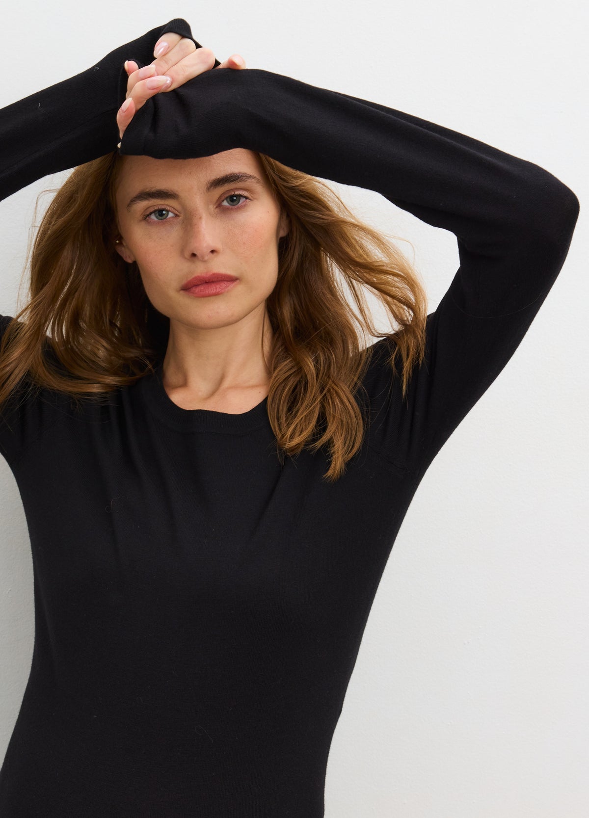Black knit long sleeve maternity tee with soft stretch fabric, designed for pregnant bodies.