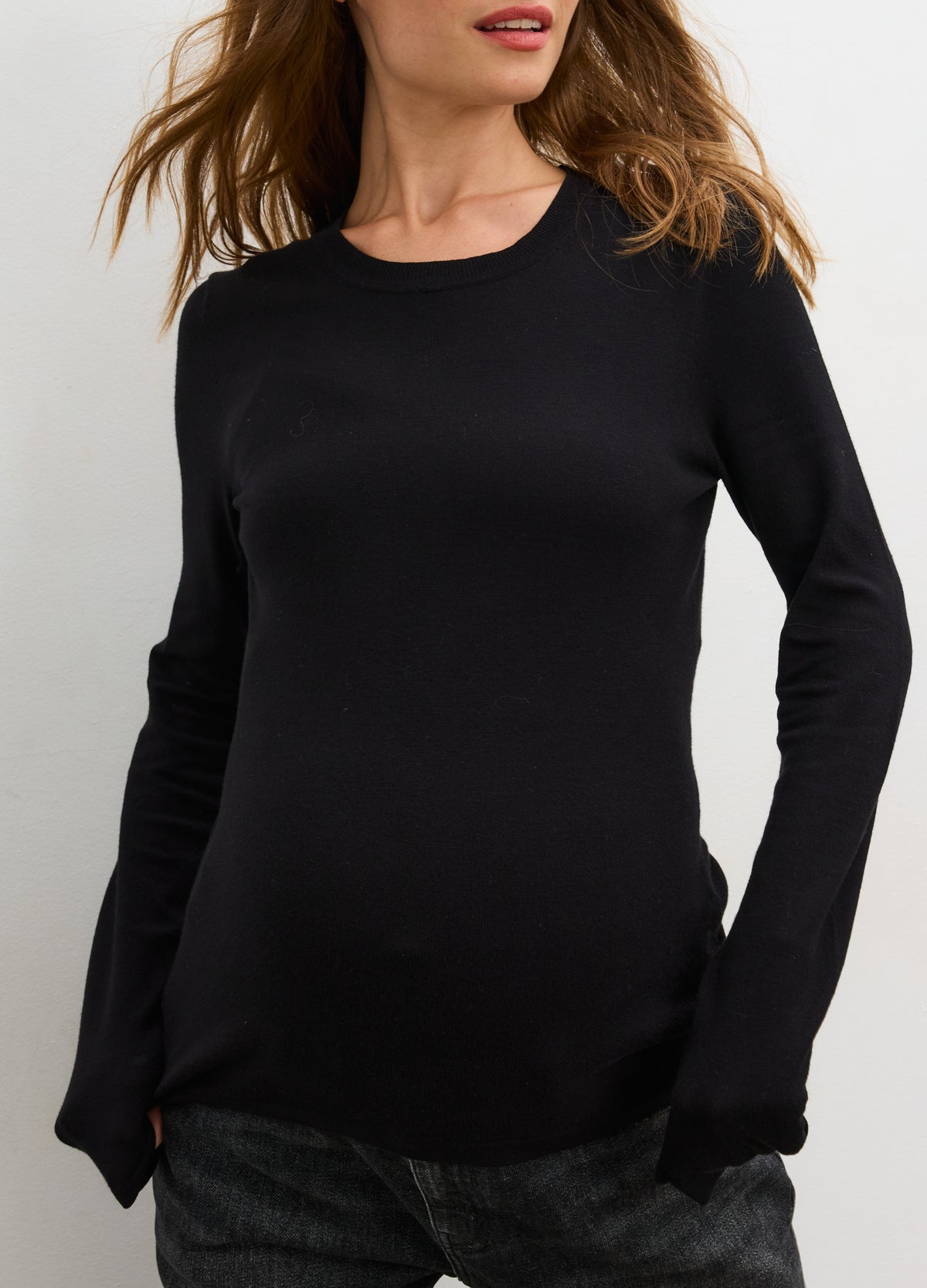 Black long-sleeve knit maternity tee with a fitted silhouette designed for pregnant comfort.