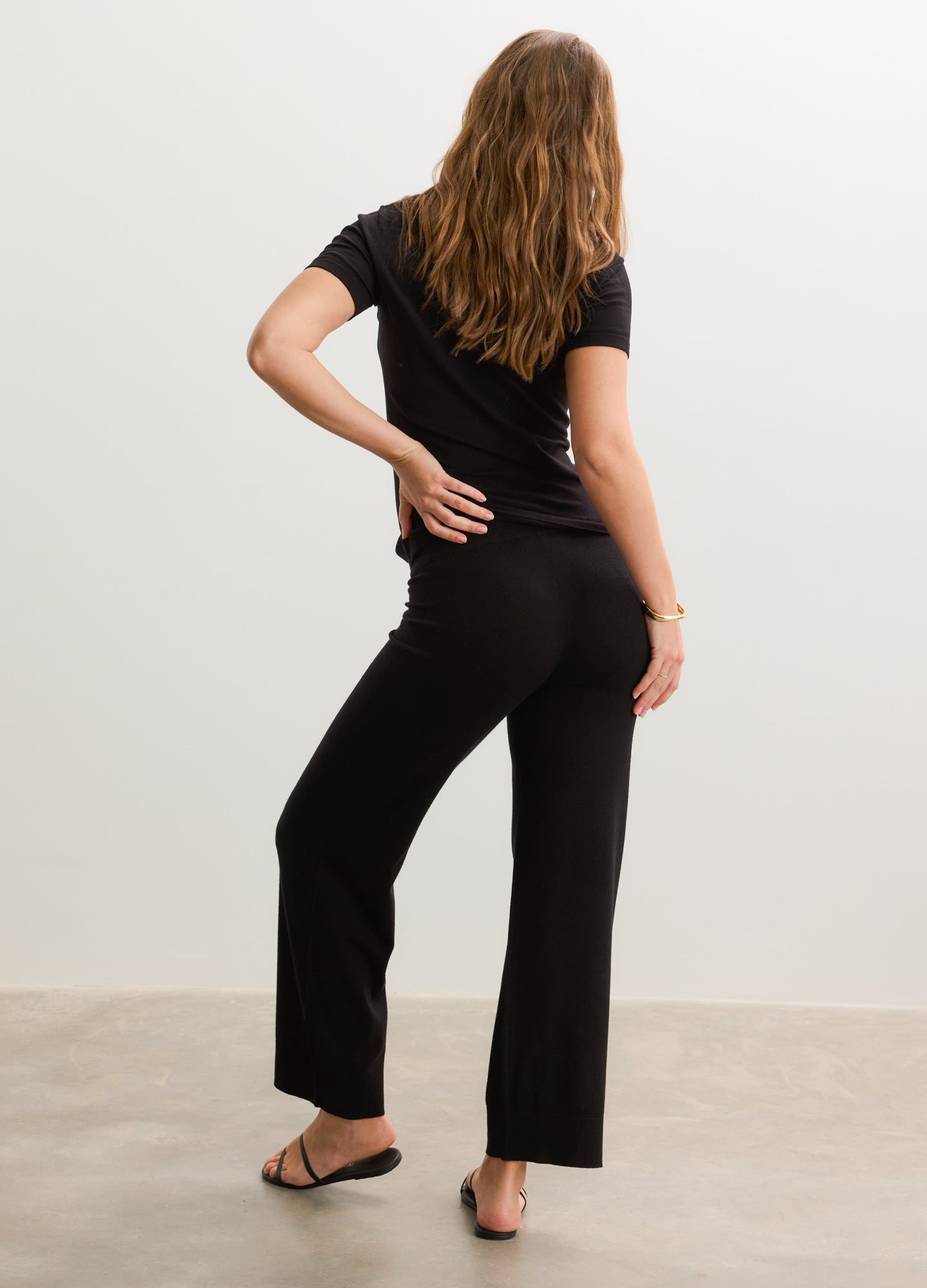 Black short-sleeve knit maternity tee with stretchy fabric paired with matching wide-leg pants.