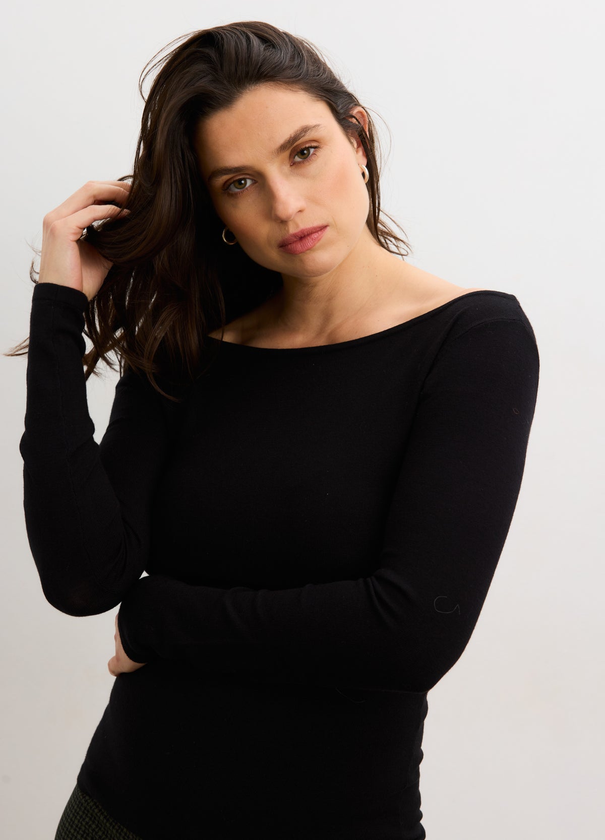 Black long-sleeve maternity top with boat neckline, fitted for pregnant silhouette.