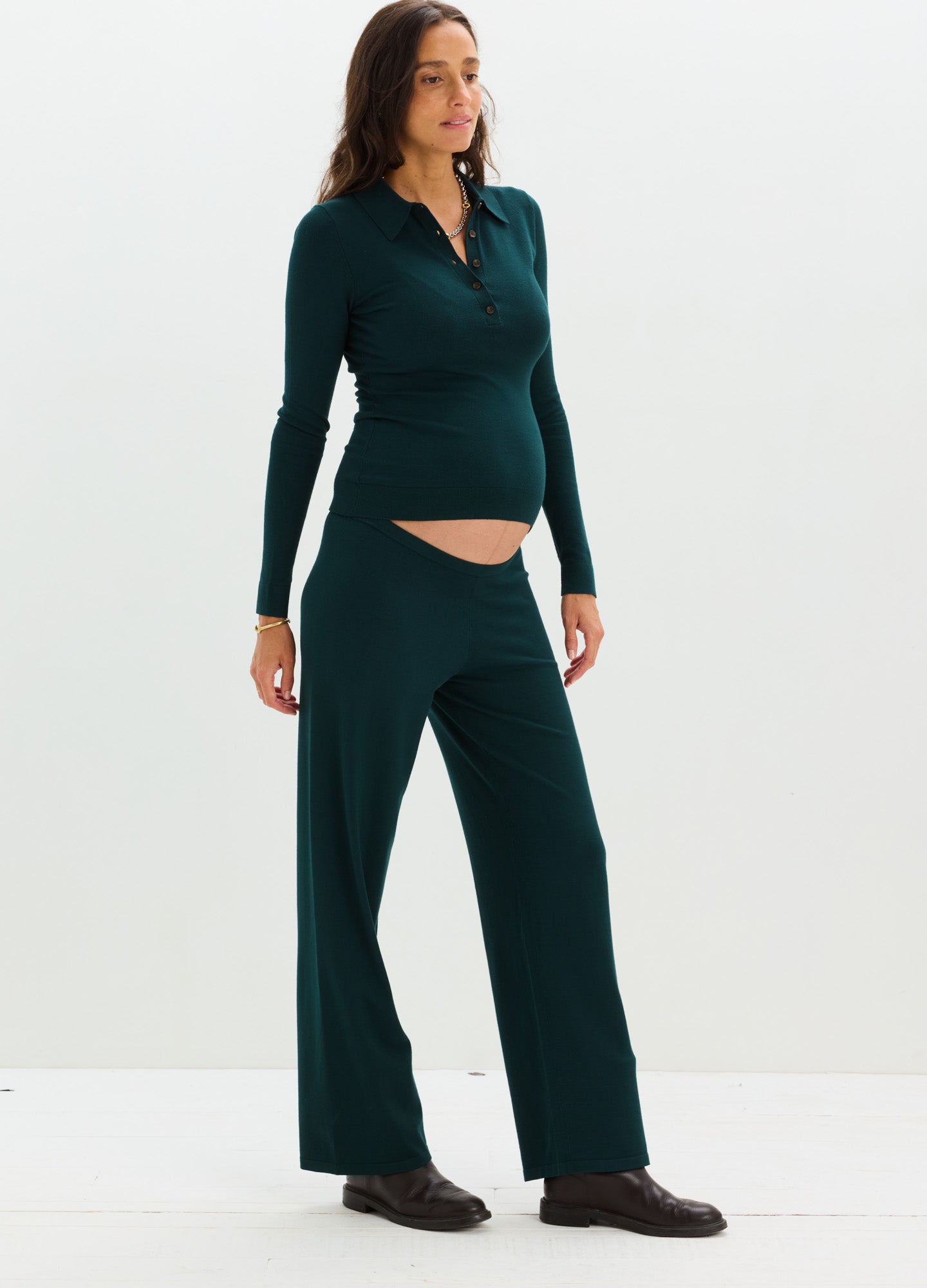 Dark teal knit maternity pants with wide legs and soft stretch panel under the belly, paired with matching long-sleeve top.