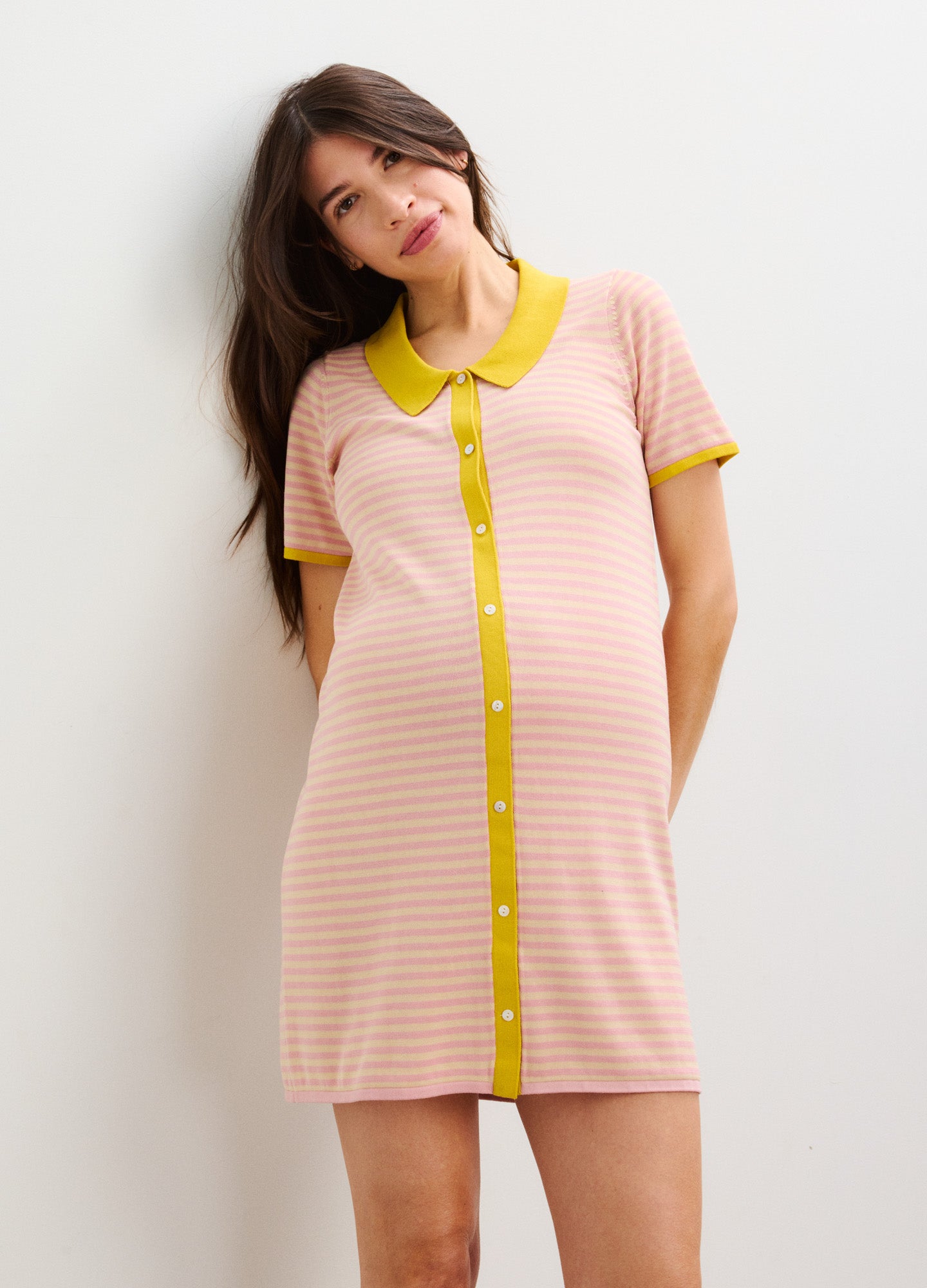 Pink and yellow striped maternity dress with short sleeves and a button-down front collar.