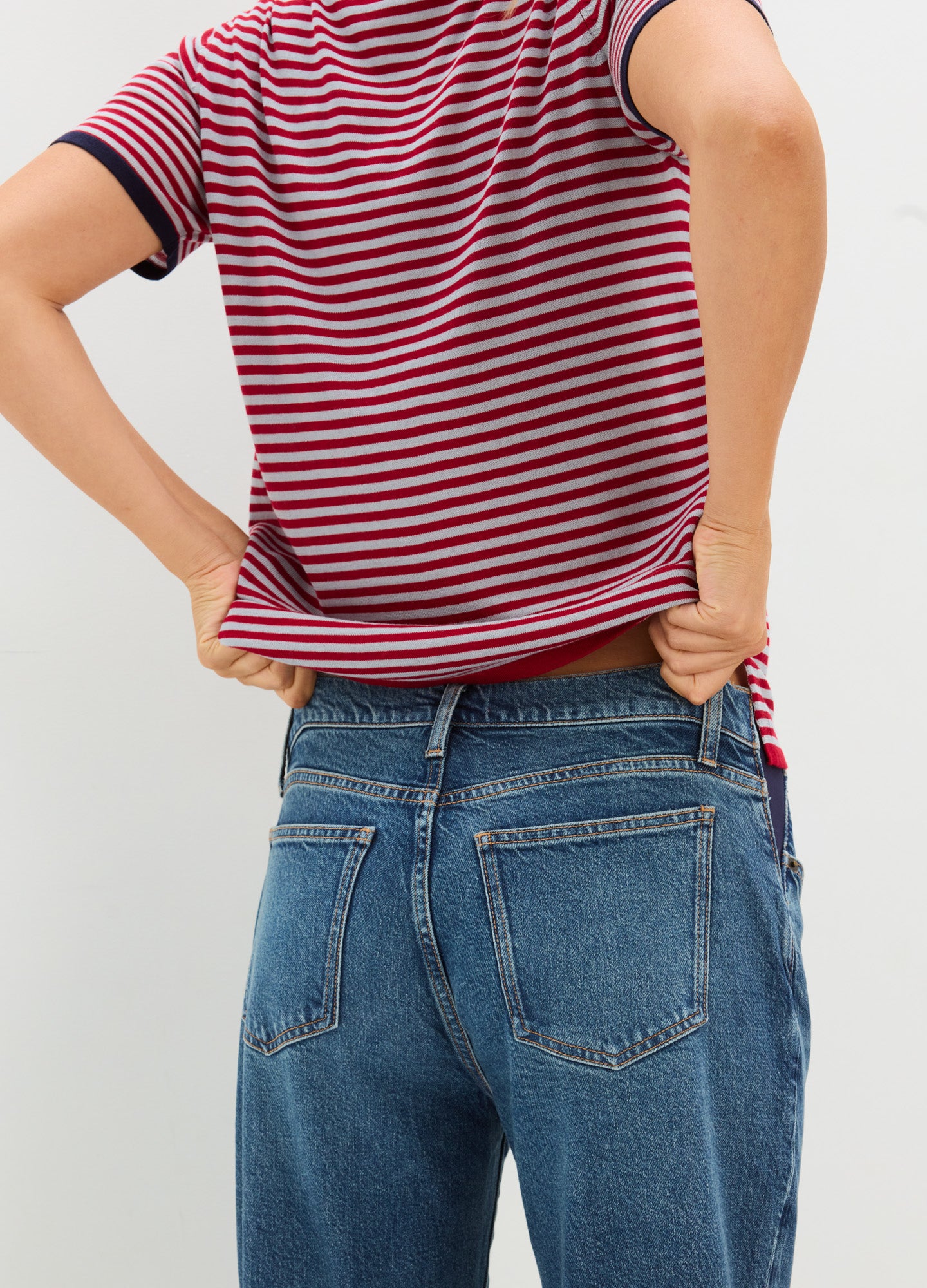 Red and navy striped short-sleeve maternity shirt with a relaxed fit on a pregnant model.