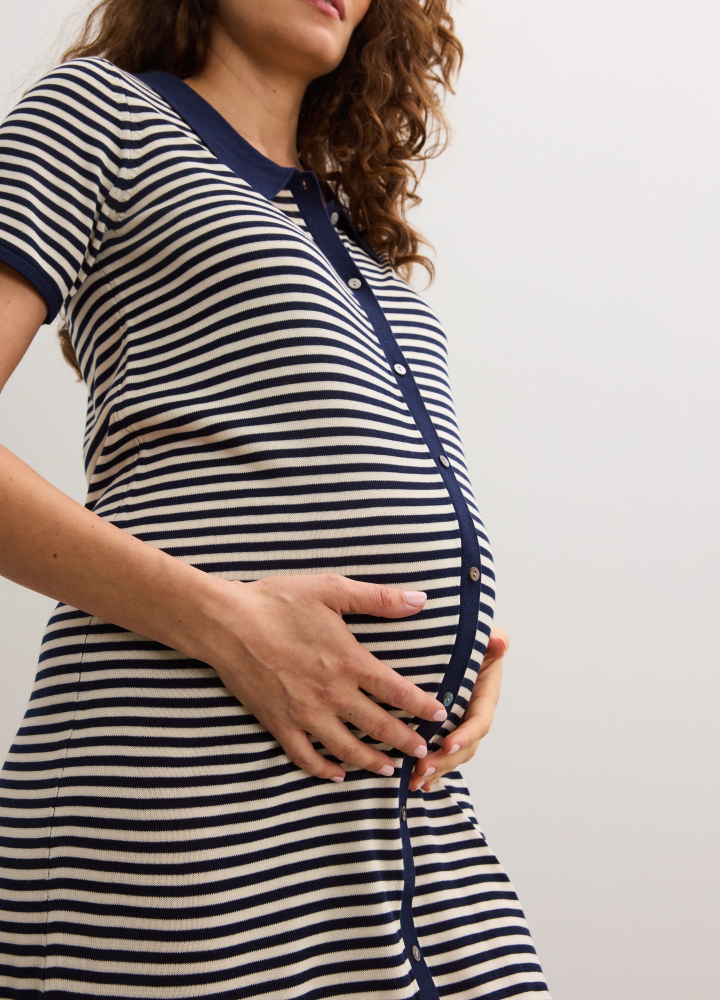 Navy and white striped short-sleeve maternity dress with button front and fitted silhouette.