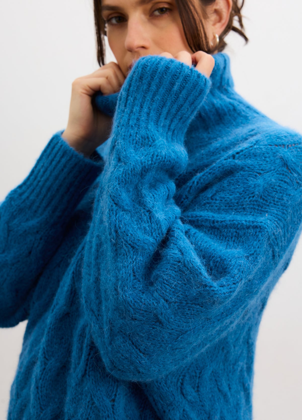 Bright blue alpaca cable-knit maternity turtleneck sweater designed for pregnant comfort.