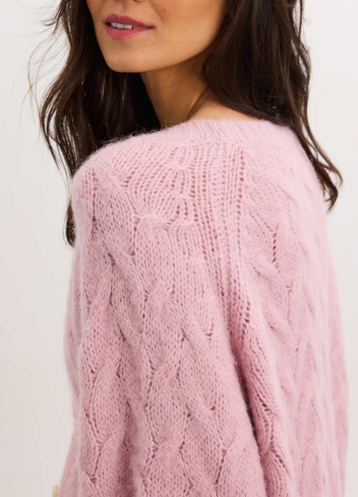 Soft pink alpaca cable knit maternity cardigan with relaxed fit and textured pattern.