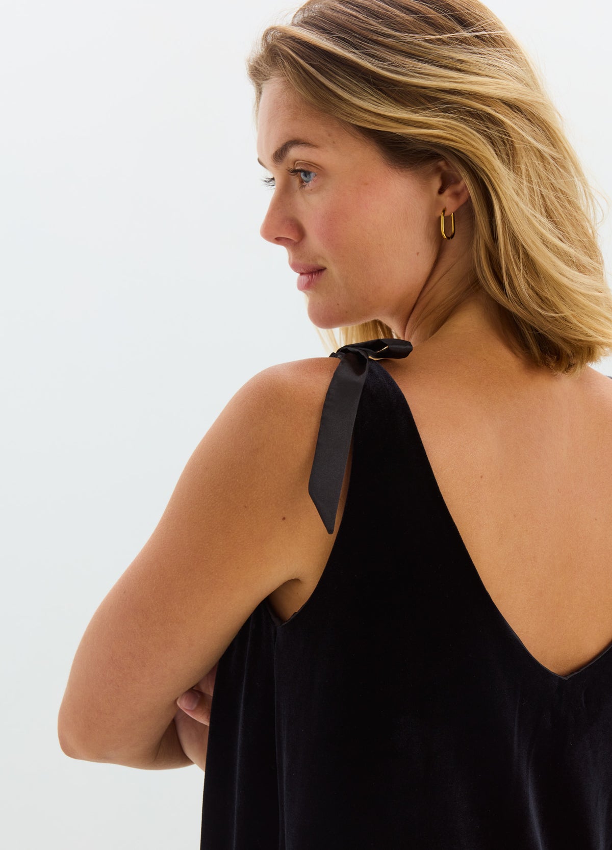 Black stretch velvet halter top with a deep V back and tied shoulder straps.