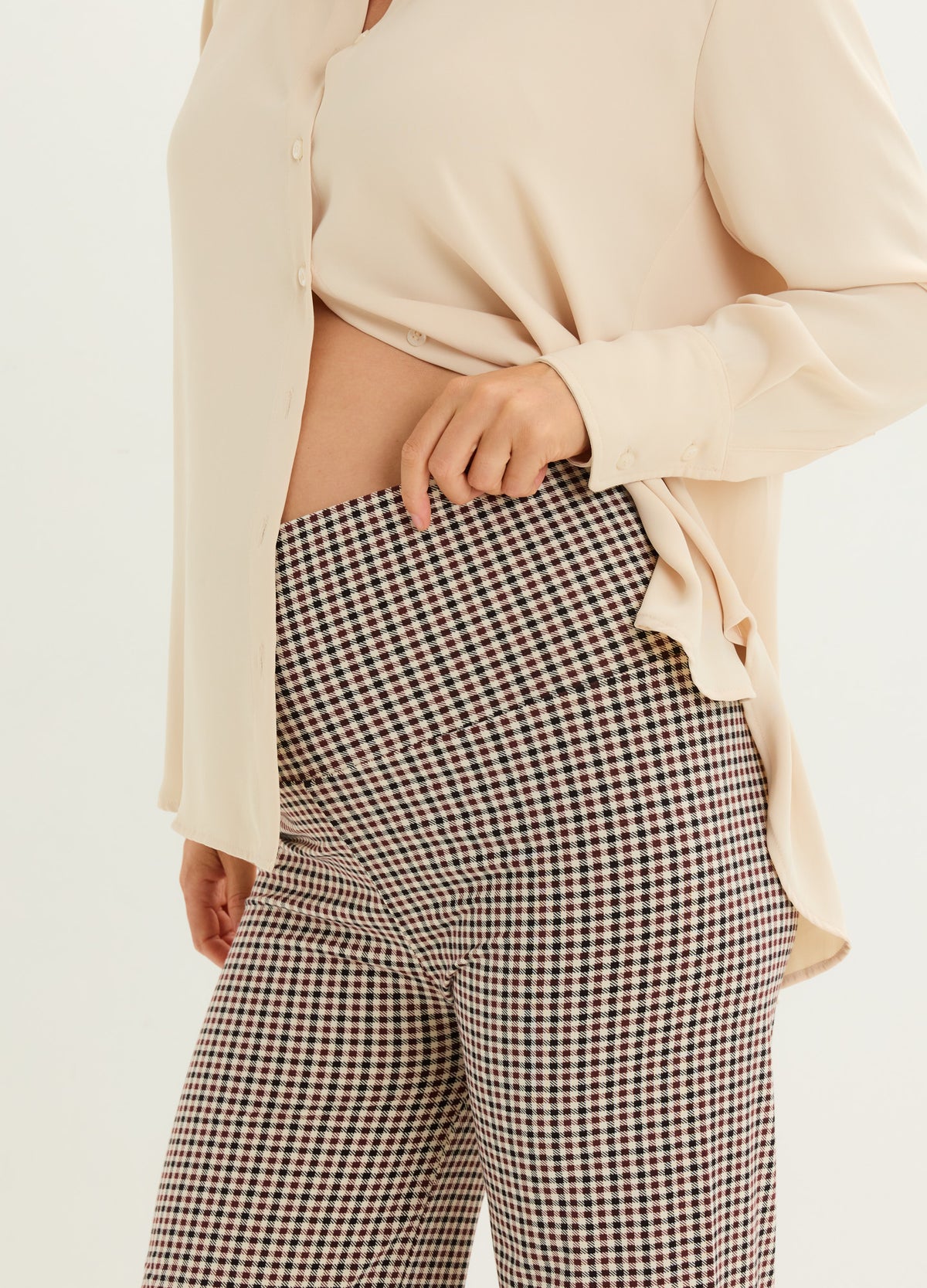 High-waist stretchy maternity pants with brown and cream houndstooth pattern, designed to fit over pregnant belly.