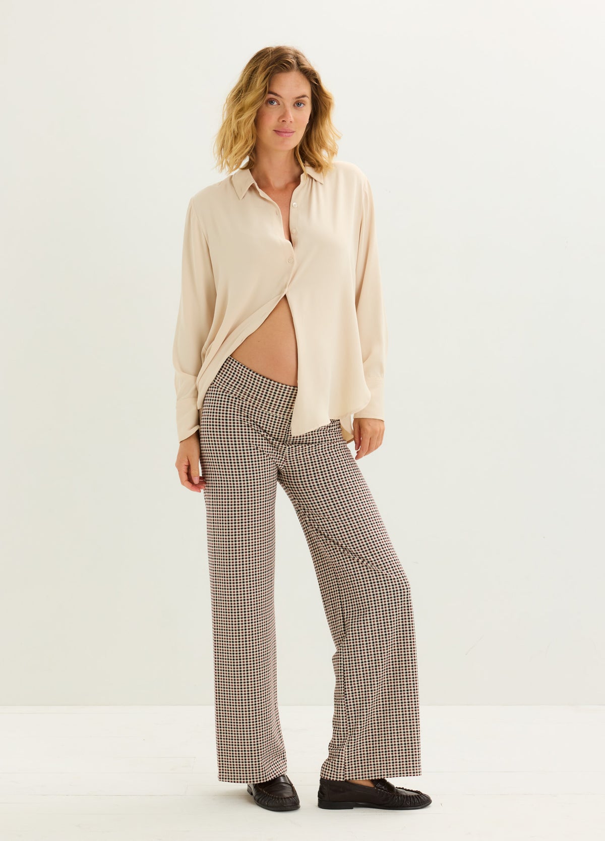 Beige button-up maternity shirt paired with high-waist, wide-leg textured brown pants designed for pregnant women.