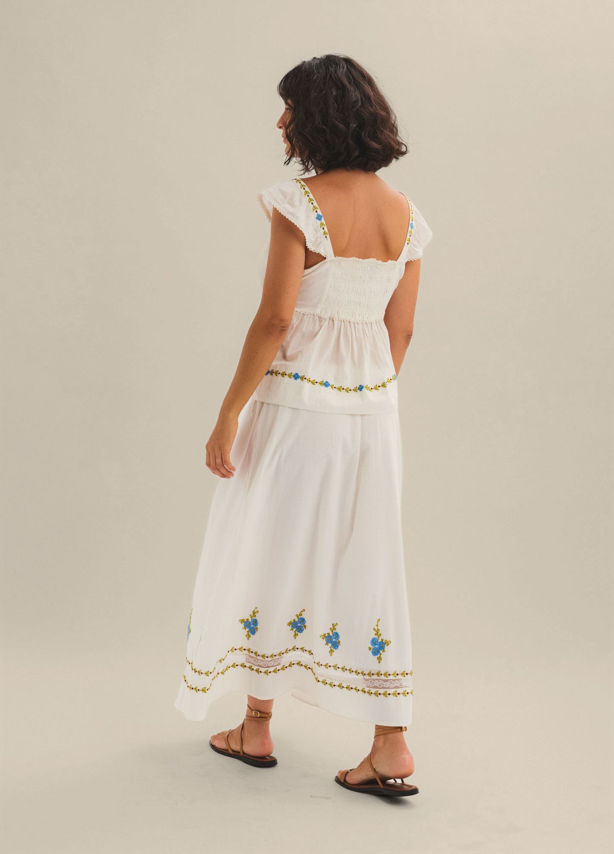 White maternity maxi skirt with embroidered floral accents and a flowy silhouette.