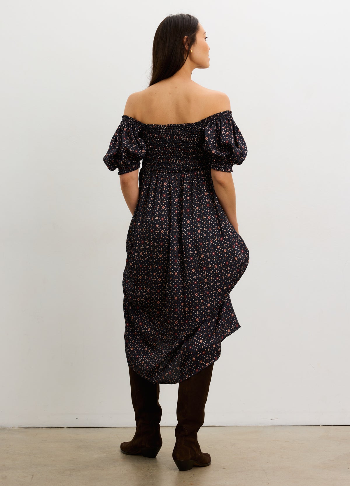 Black off-the-shoulder maternity dress with puff sleeves and a flowing midi skirt.