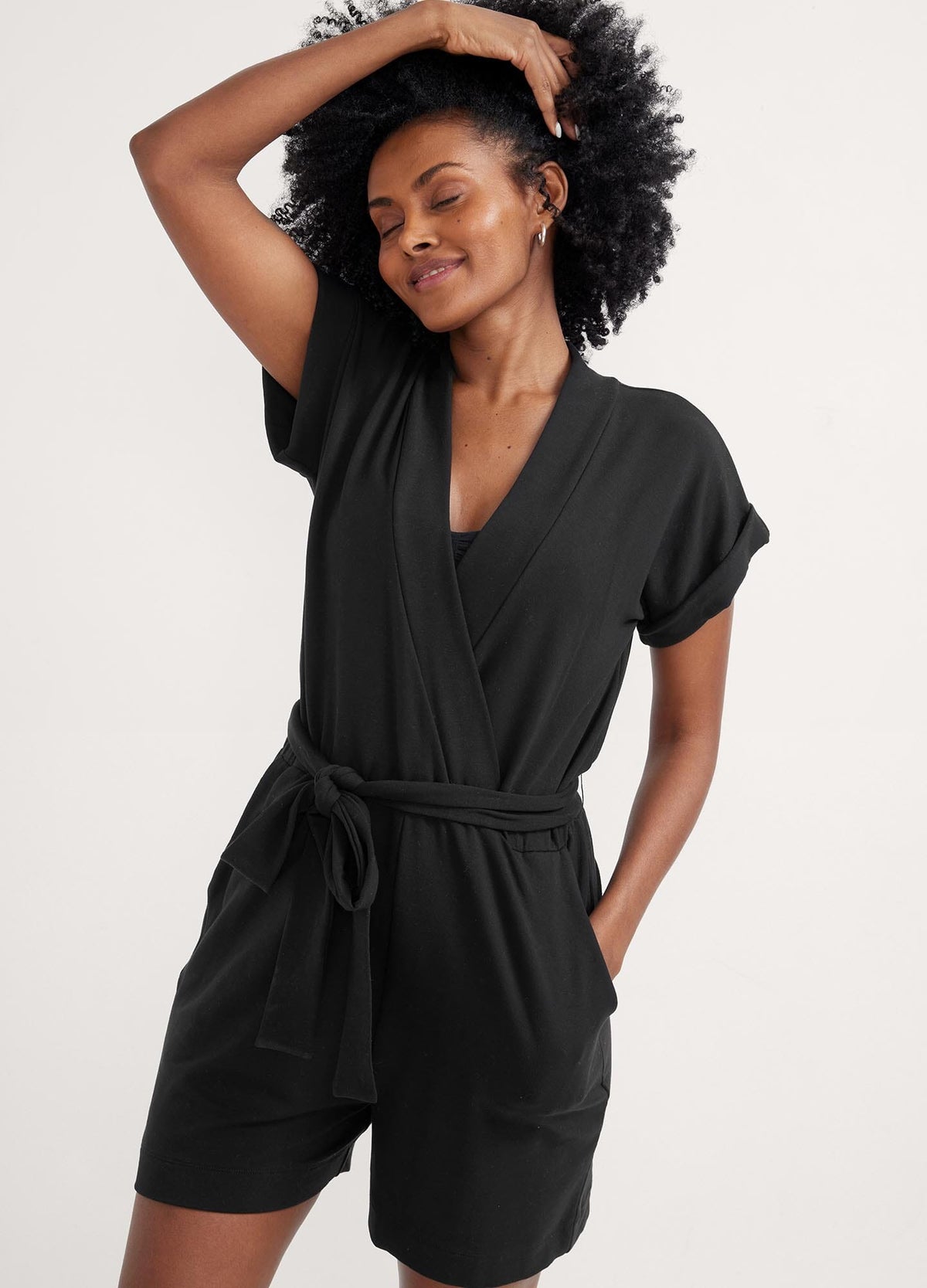 The Nurse-To-Errands Romper - Blush maternity romper with short sleeves, V-neck nursing access, and a waist tie for postpartum comfort.