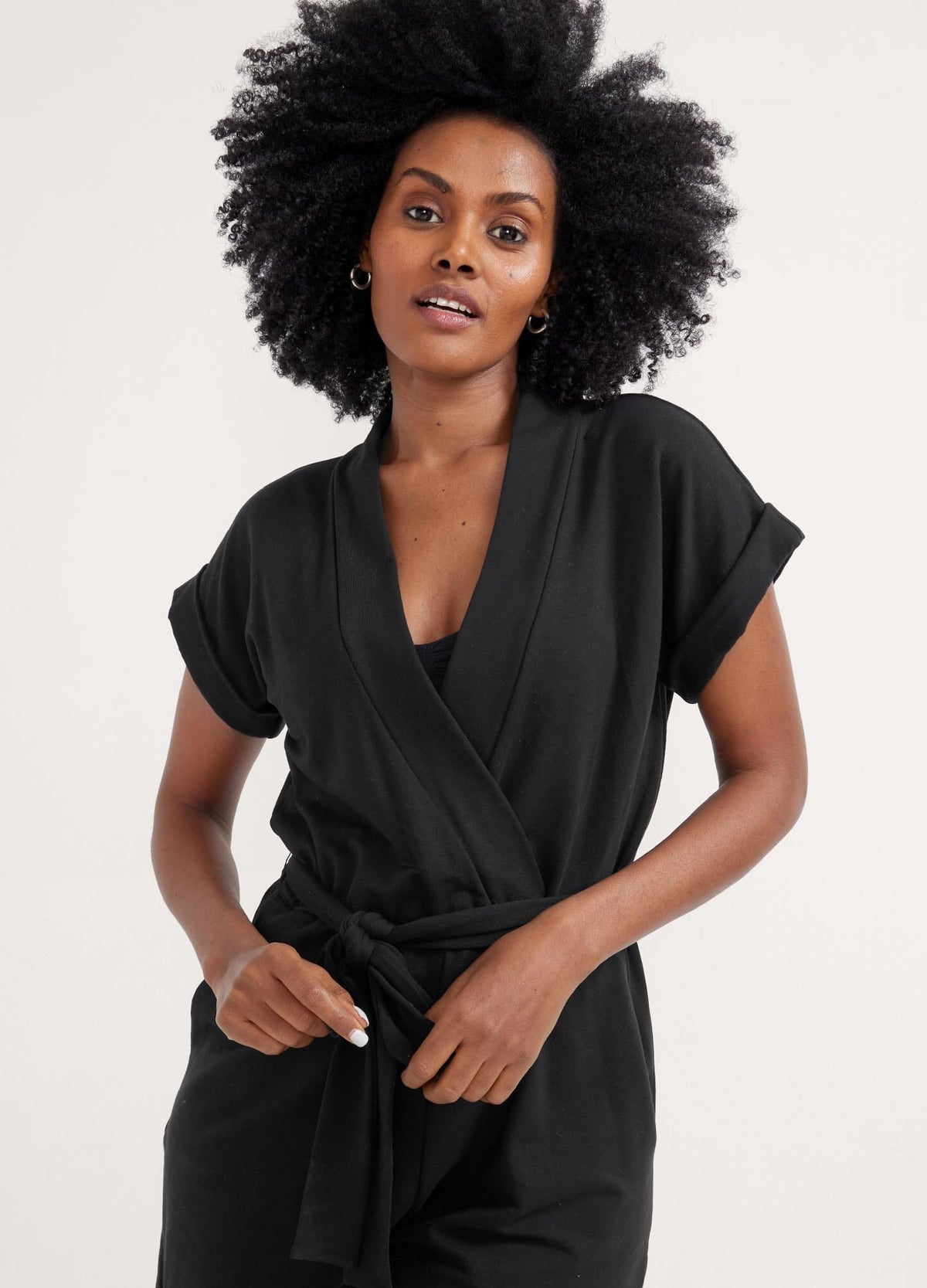 The Nurse-To-Errands Romper - Blush maternity romper with short sleeves, V-neck nursing access, and a waist tie for postpartum comfort.