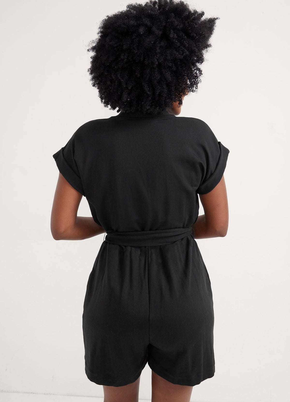 The Nurse-To-Errands Romper - Blush maternity romper with short sleeves, V-neck nursing access, and a waist tie for postpartum comfort.