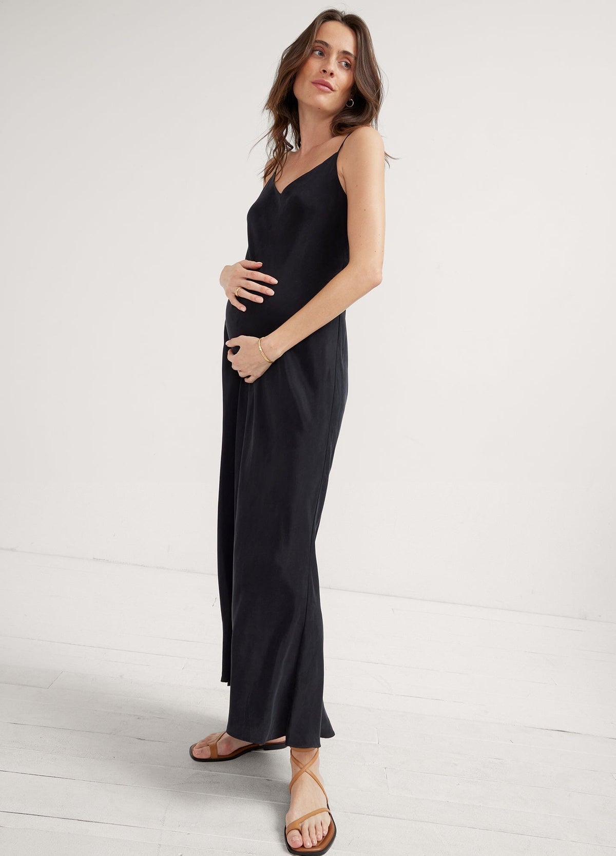 The Ricky Slip Dress - Black maternity slip dress with adjustable straps, designed for pregnancy, nursing, and postpartum, worn with casual ease.