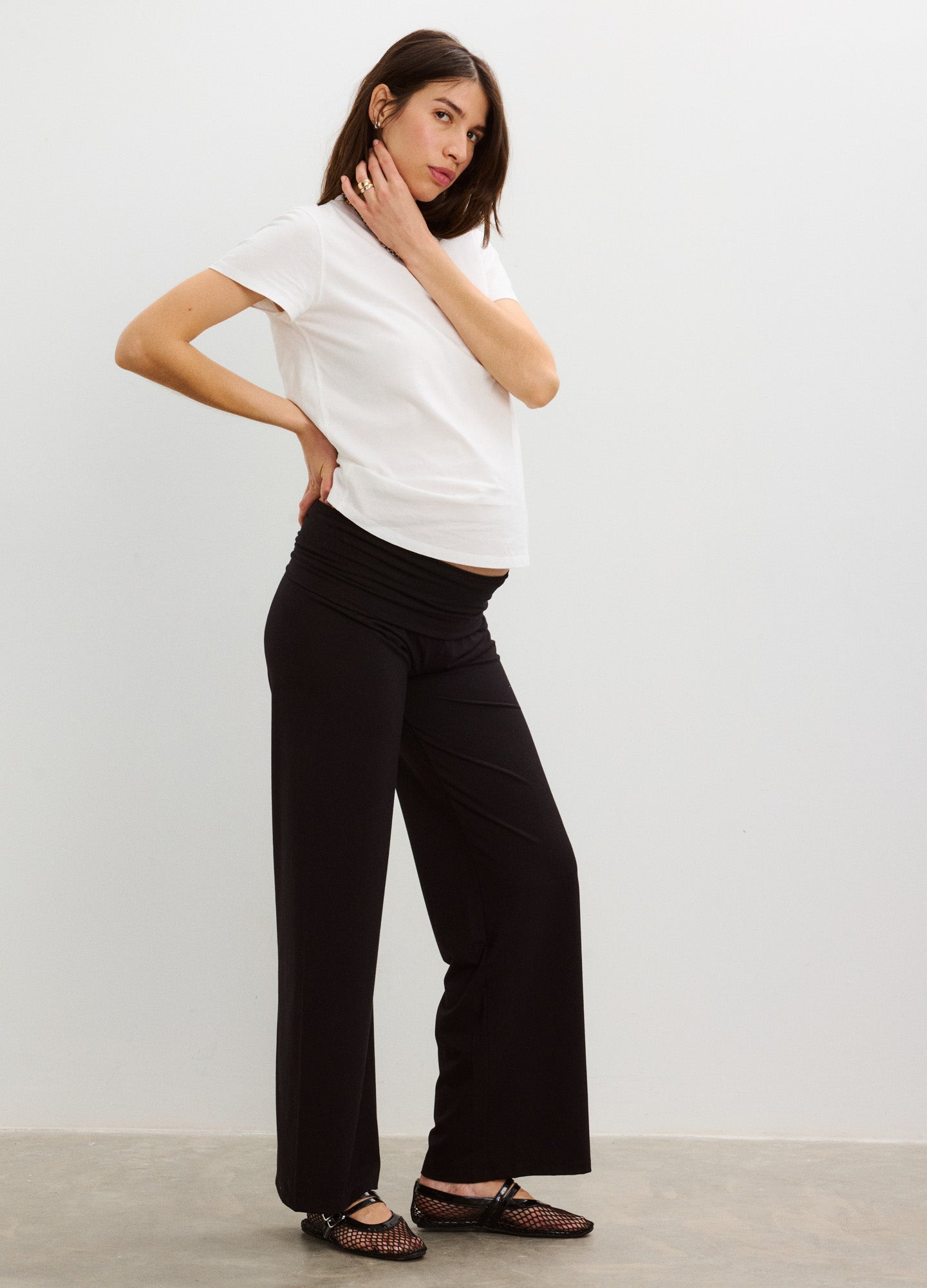 White short-sleeve maternity crew neck cotton t-shirt paired with black wide-leg pants.