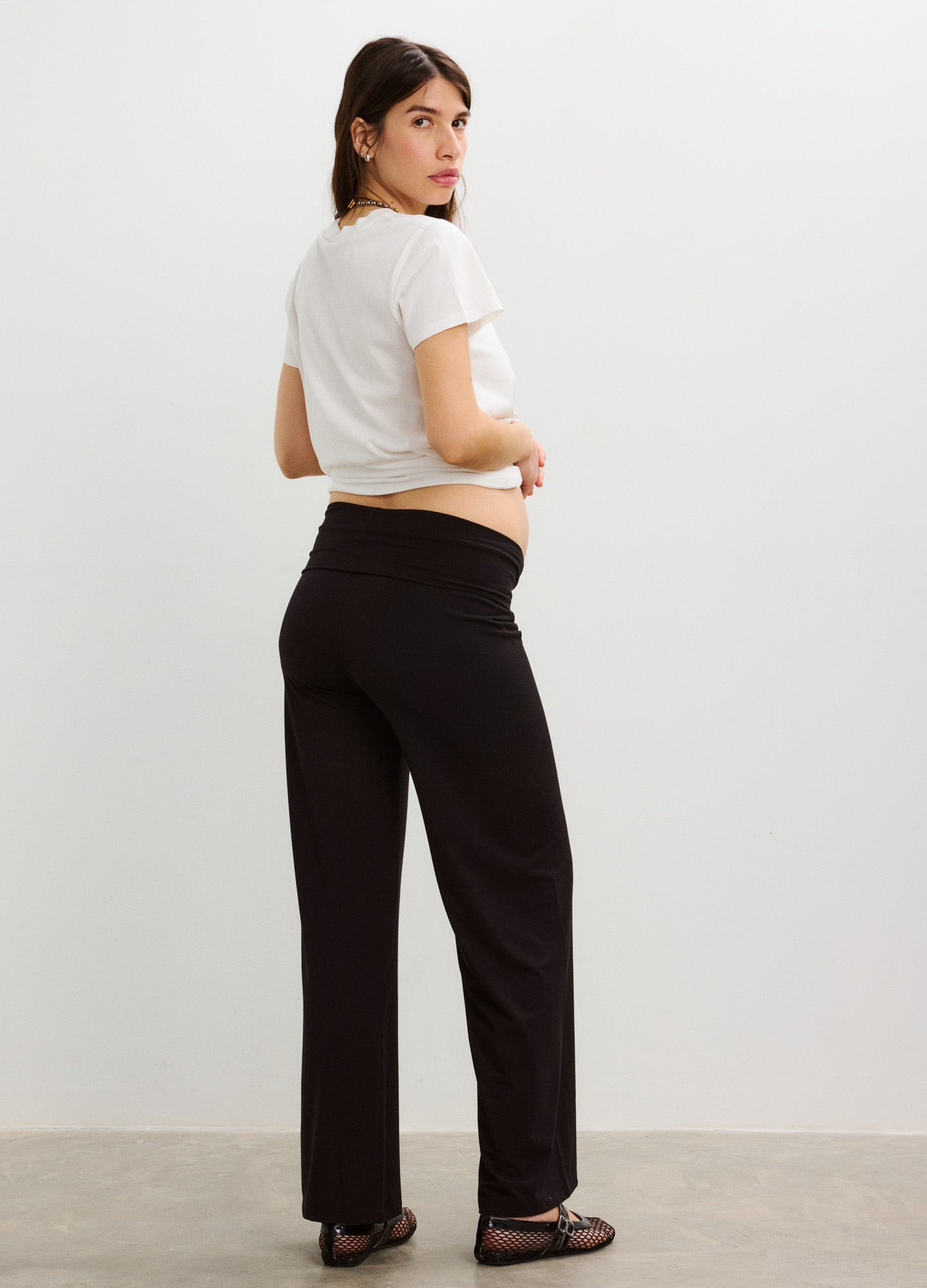 White short-sleeve maternity crew neck t-shirt paired with black comfortable wide-leg pants.