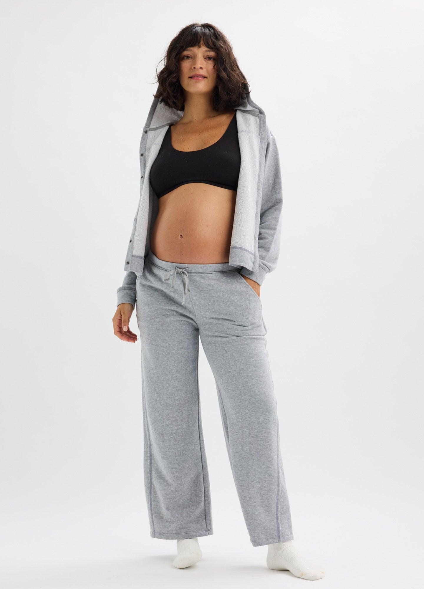 Light gray soft maternity pants with wide legs and a comfortable elastic waistband, styled with a matching hoodie and black.