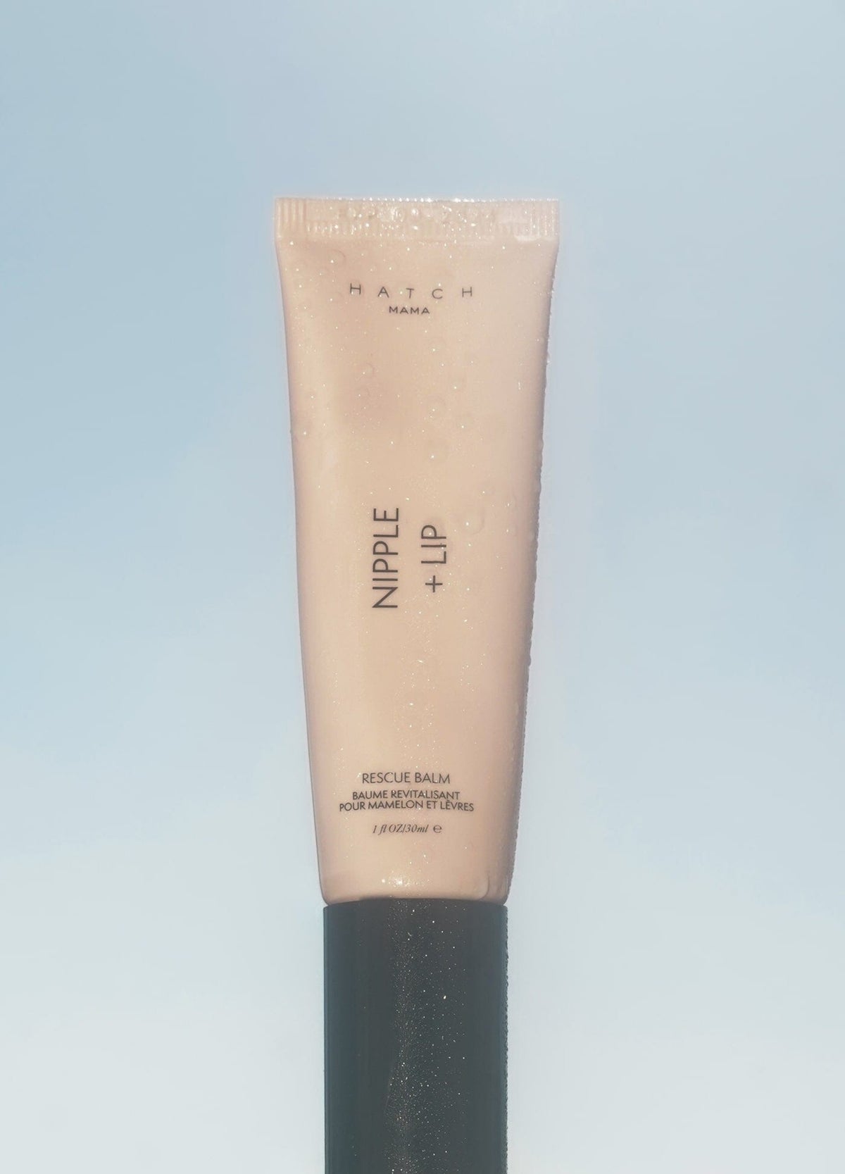 Beige tube of Nipple + Lip balm with black cap, designed for pregnant and maternity skin care.