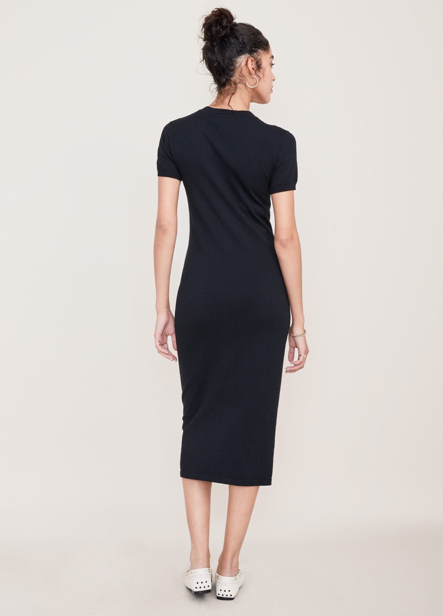 The Eliza Dress POS - Black short-sleeve maternity dress with nursing-friendly design and fitted silhouette, styled with tall black boots.