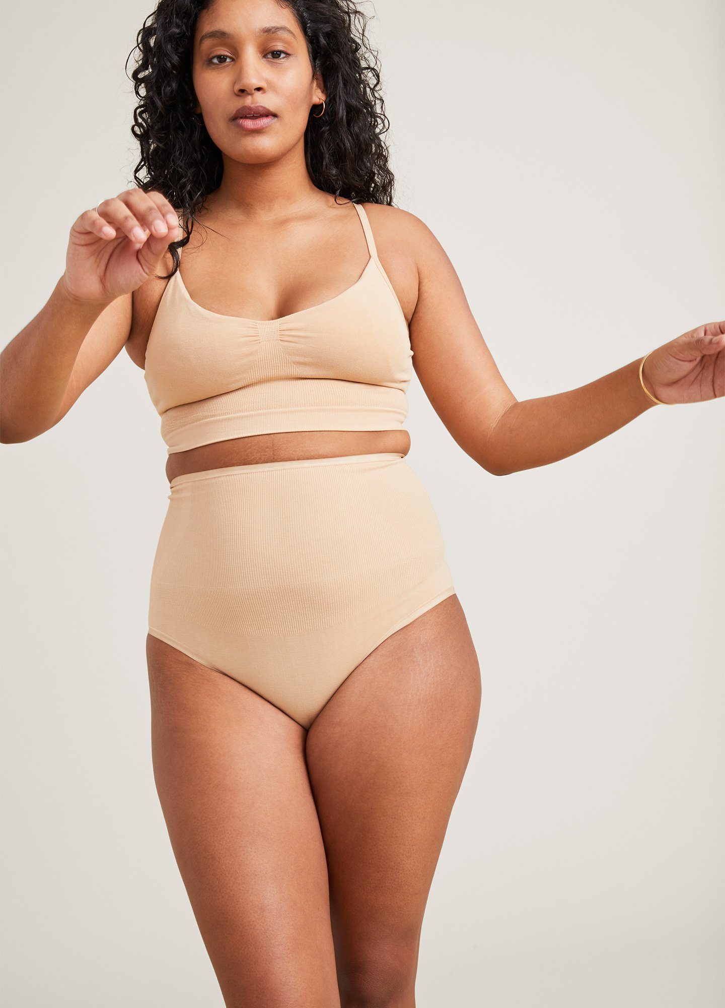 Beige seamless maternity pumping bra with soft, stretchy fabric and wide underband for support.