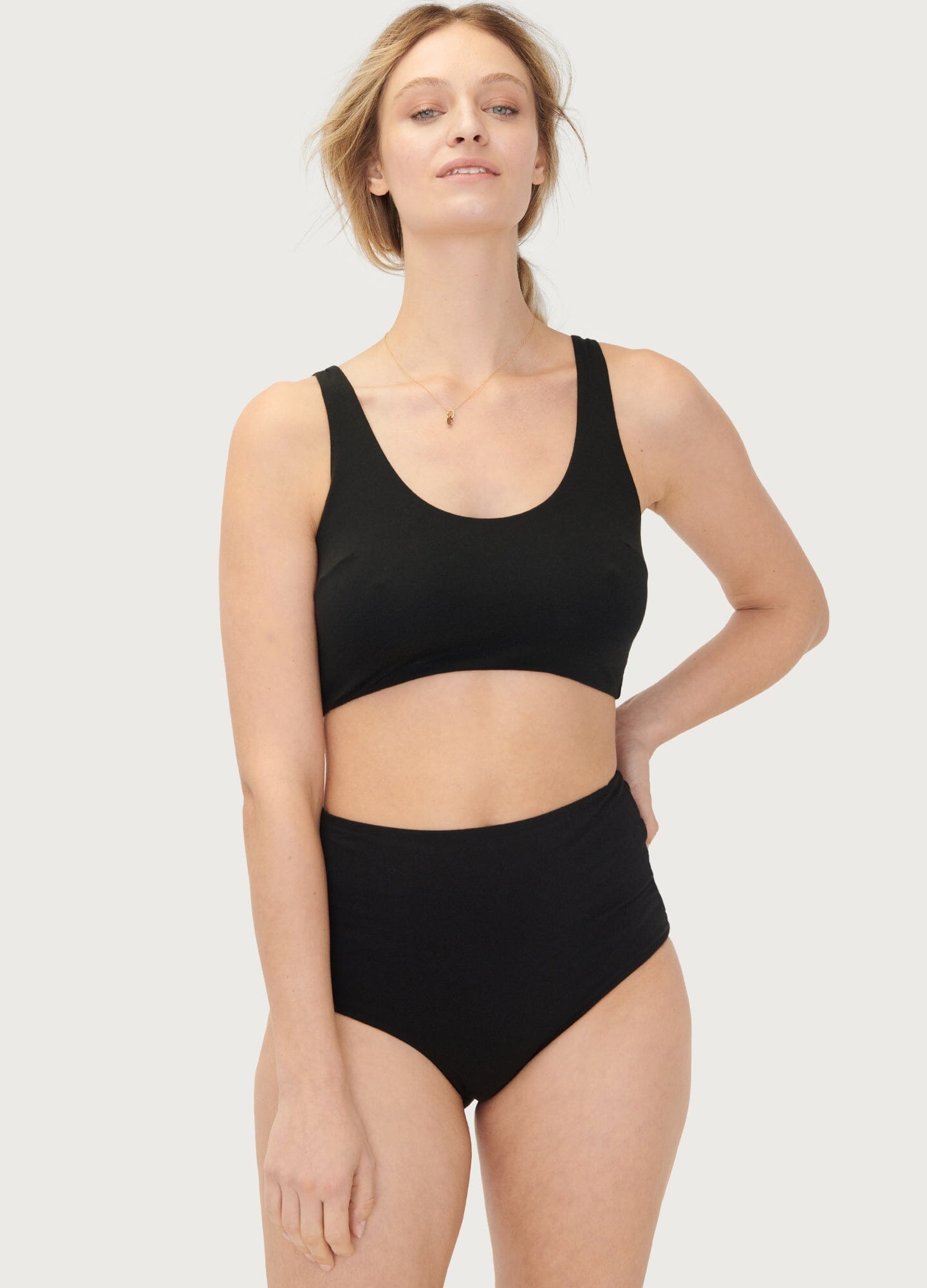 Black seamless maternity bra with wide straps and scoop neckline on slender model.